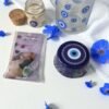 2025/09/1000225223.jpg 🧿 Kit Olho Místico – Proteção Kit 7 Pedras da Sorte + Caneca de Vidro Olho Grego 230ml+ Vela Olho Grego + Sabonete Exclusivo Olho Grego(com energia Reiki)